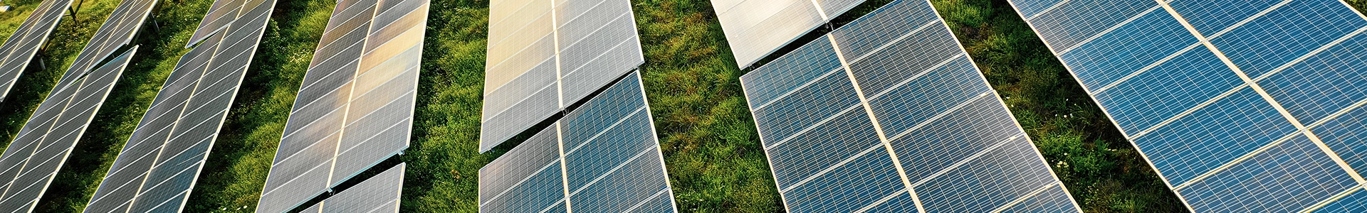 Aerial view of solar panel arrays installed across a grassy landscape, capturing sunlight for renewable energy production.
