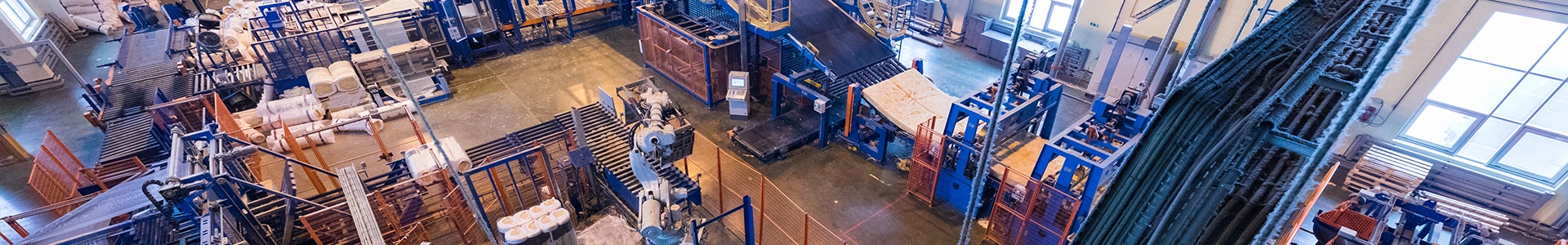 Wide view of an industrial manufacturing facility with automated machinery, production lines, and equipment in operation.