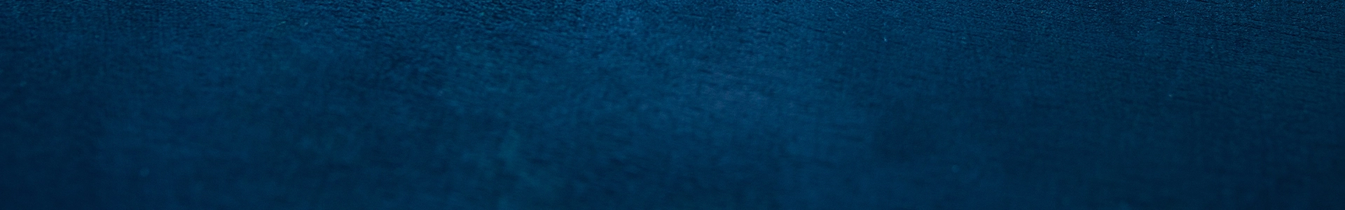 Dark blue textured background with subtle gradients and a soft, velvety surface appearance.