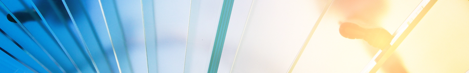 Abstract view of a person walking on glass panels with blue and warm light shining through.