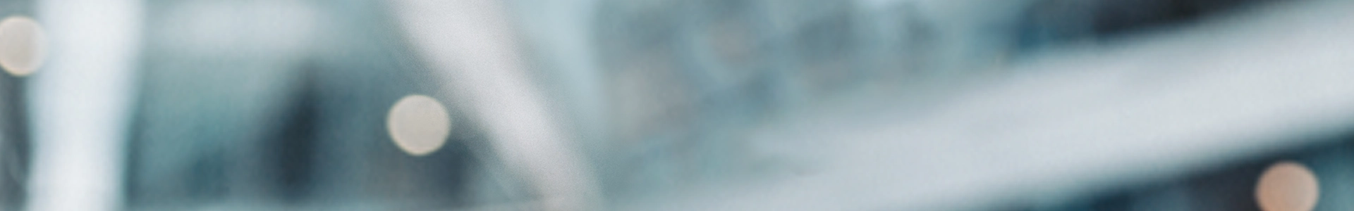 Blurred abstract background with soft blue and white tones. Circular lights create a bokeh effect, conveying a calm and serene atmosphere.